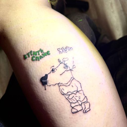 Тату на ноге: поплывшый кинокефал мультяшный чиловая с надписью «курить спайс очень плохо»