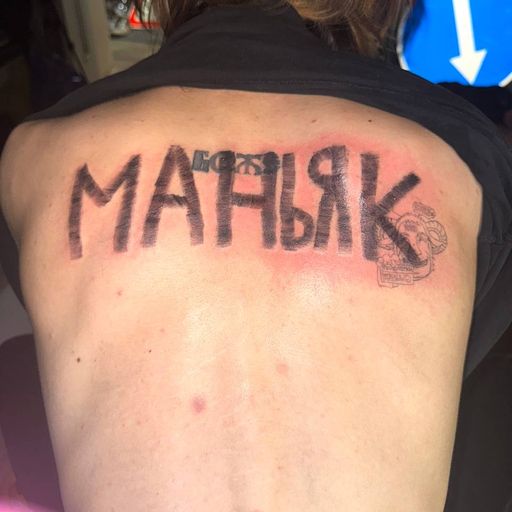 Тату на спине: крупная надпись «МАНЬЯК»